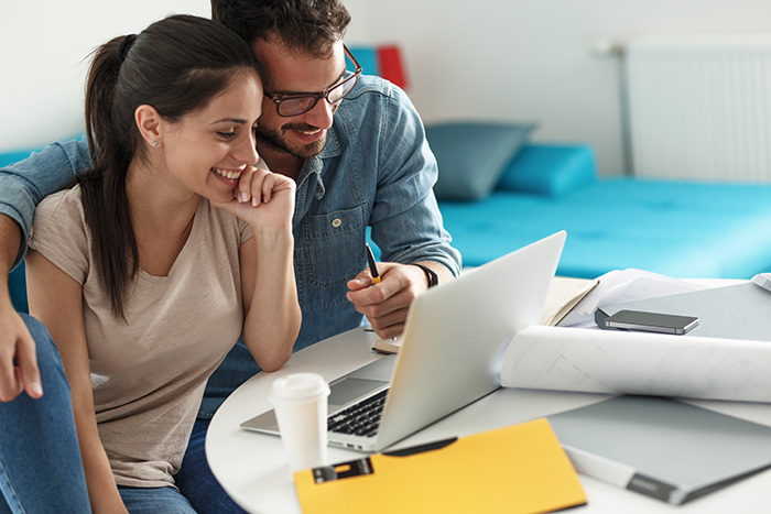 Man and woman smiling at a laptop together