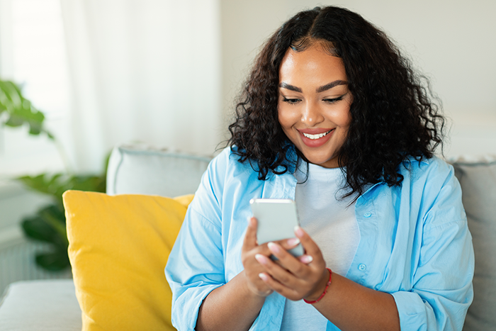 Woman smiling at her smartphone in her hands