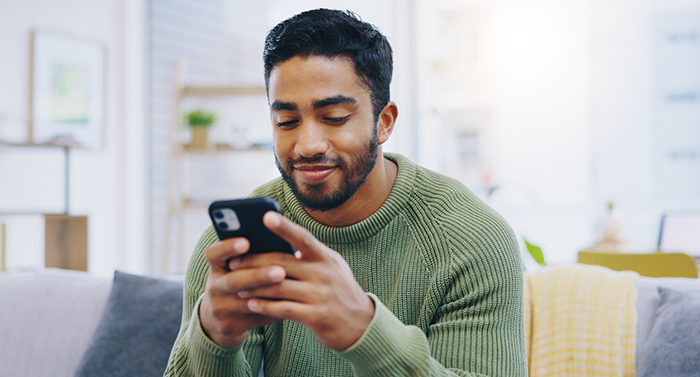 Man smiling at his smartphone in his hand